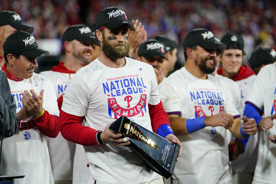 Philadelphia Phillies designated hitter Bryce Harper celebrates with the trophy after winning the baseball NL Championship Series in Game 5 against the San Diego Padres on Sunday, Oct. 23, 2022, in Philadelphia. (AP Photo/Matt Slocum)