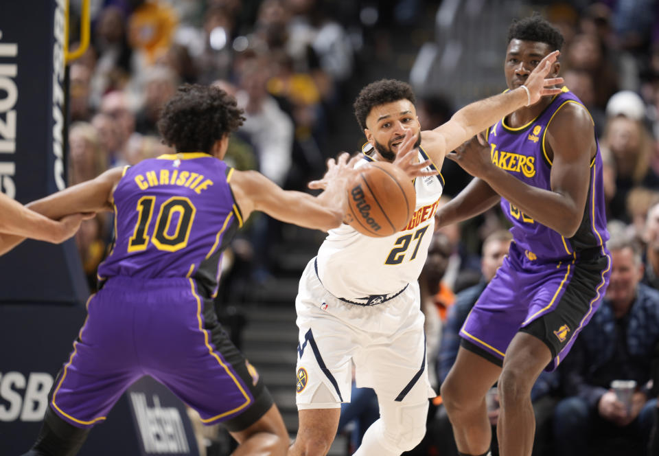 Denver Nuggets guard Jamal Murray, center, fights for control of the ball with Los Angeles Lakers guard Max Christie, left, and center Thomas Bryant in the first half of an NBA basketball game Monday, Jan. 9, 2023, in Denver. (AP Photo/David Zalubowski)