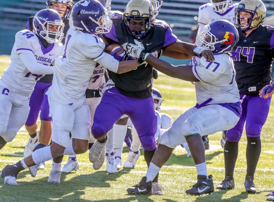 St. Raphael running back Henrique Ross struggles for yardage against a swarming Classical defense during Saturday's Division II Super Bowl, won by the Purple, 28-14.