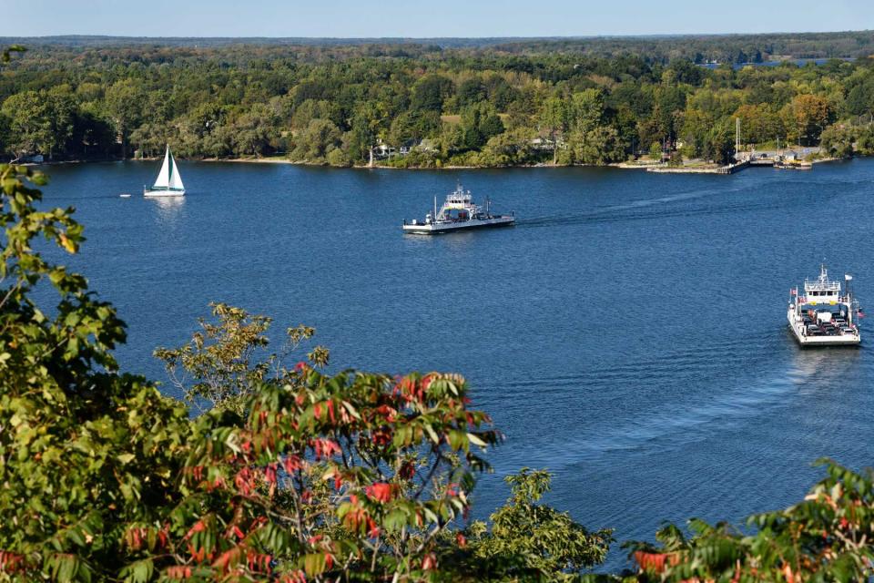 Free Glenora car Ferries to Adolphustown on blue Adolphus Reach with white sailboat on Bay of Quinte, Prince Edward County Ontario in Fall