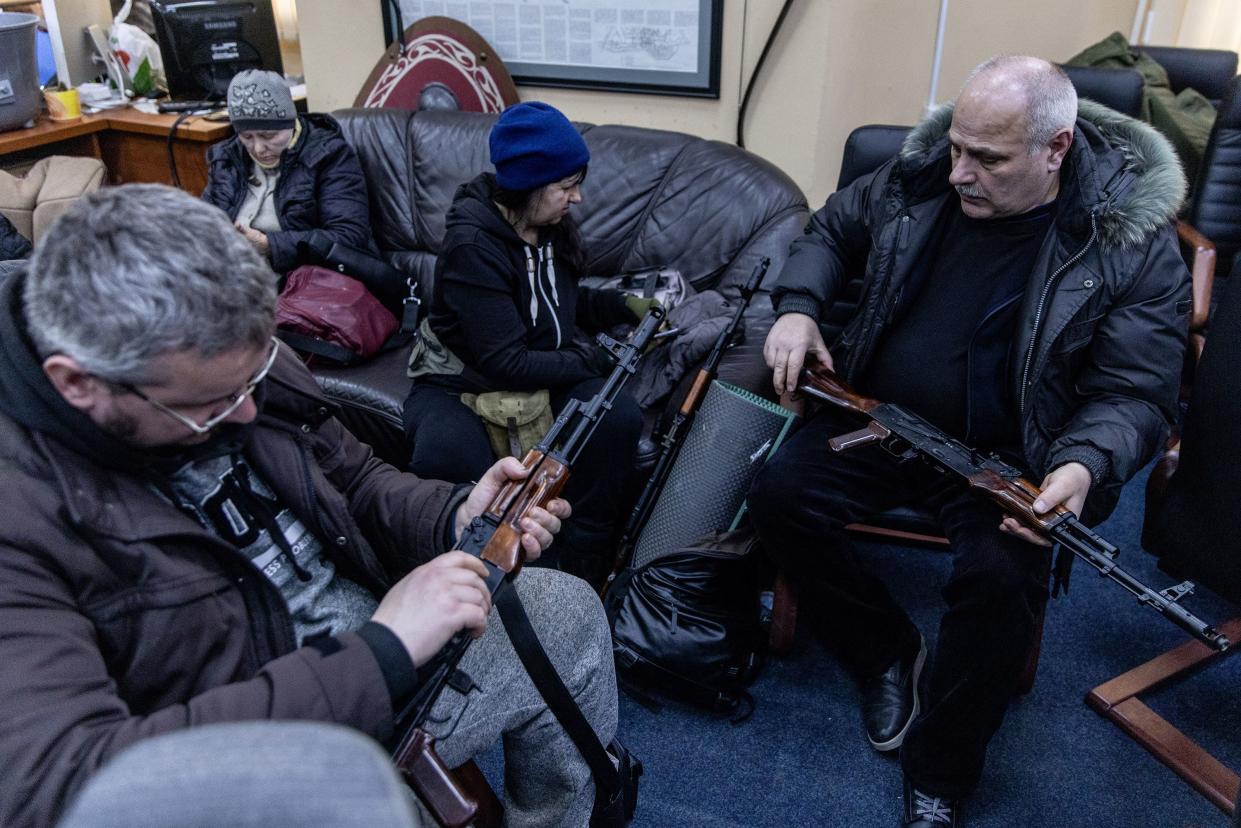 Civilian volunteers check their guns at a  Territorial Defence unit registration office on Feb. 26, 2022, in Kyiv, Ukraine. Explosions and gunfire were reported around Kyiv on the second night of Russia's invasion of Ukraine.