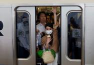 FILE PHOTO: Passengers ride a crowded train at a station in Kawasaki