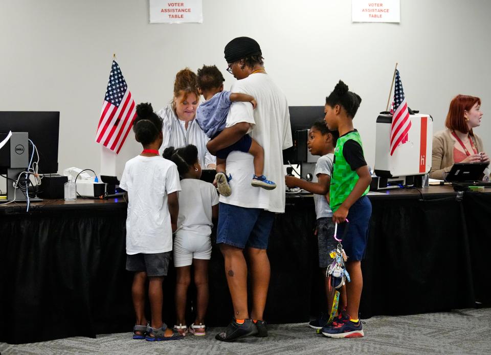 Darnell Bush, of Madisonville, checks in at the Board of Elections to vote, Monday, July 17, 2023. Bush brought her five grandchildren with her. They all got ‘future voter’ stickers. Early voting is taking place now at BOE in Norwood on Issue 1, which, if passed, would make it harder to amend the state’s constitution. The special election is Aug. 8. 