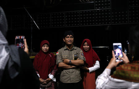 Staff at Boshe VVIP Club pose for pictures with Mifta'im An'am Maulana Habiburrohman, or Gus Miftah, a 37-year-old Muslim preacher who aims to create a safe space to worship for those who work in the entertainment industry, at one of his sermons in Kuta, Bali, Indonesia November 27, 2018. REUTERS/Nyimas Laula/Files