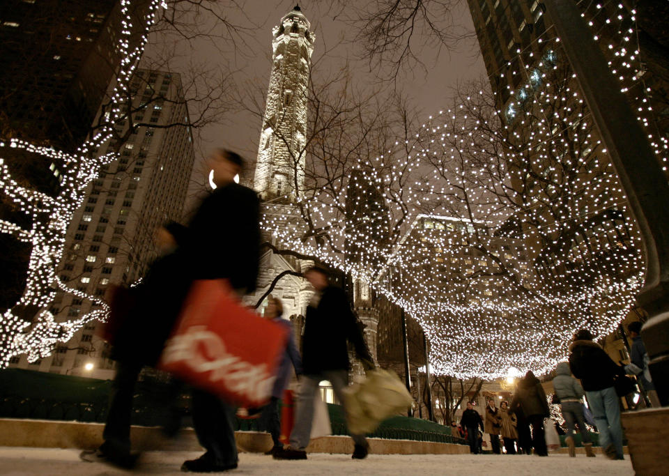 FILE - In this Nov. 25, 2005 file photo, shoppers walk under lights strung up for the holidays around Chicago's landmark Water Tower on Michigan Avenue in Chicago. A walk along The Magnificent Miles is a great, free way to take in Chicago's history, architecture and shopping. (AP Photo/Jeff Roberson, File)