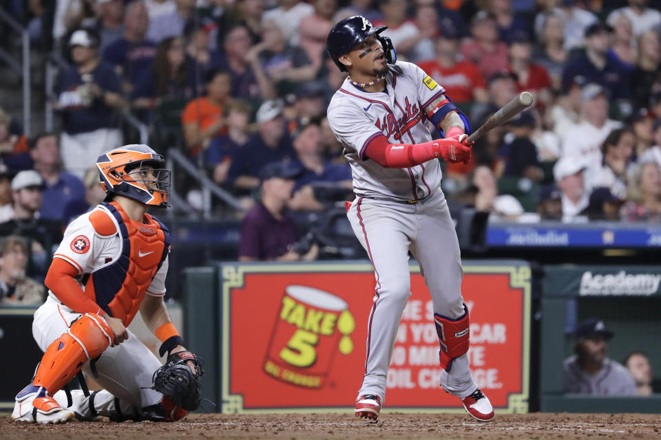 Atlanta Braves' Orlando Arcia, right, watches his sacrifice fly to center field next to Houston Astros catcher Yainer Diaz, left, scoring Austin Riley during the seventh inning of a baseball game Tuesday, April 16, 2024, in Houston. (AP Photo/Michael Wyke)