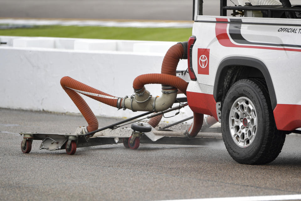 A truck from the track drying team helps dry pit road before the start of the NASCAR Xfinity Series auto race at Richmond Raceway, Saturday, April 1, 2023, in Richmond, Va. (AP Photo/Mike Caudill)