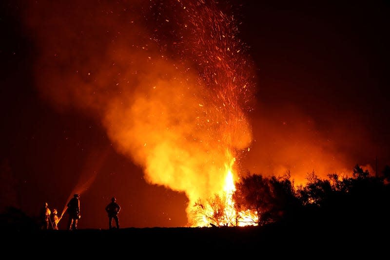 Cal Fire firefighters monitor a back fire as they battle the Mendocino Complex fire on August 7, 2018 near Lodoga, California.