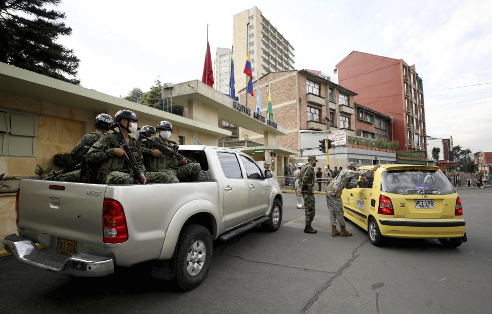 Soldiers stand guard outside the military hospital where Defense Minister Carlos Holmes Trujillo died of complications of COVID-19 in Bogota, Colombia, Tuesday, Jan. 26, 2021. President Ivan Duque said that Trujillo died early Tuesday. (AP Photo/Fernando Vergara)