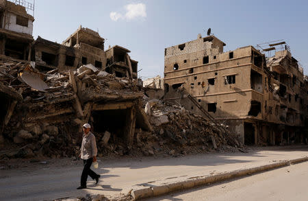 A man walks along a damaged street in Yarmouk Palestinian camp in Damascus, Syria October 10, 2018. Picture taken October 10, 2018. REUTERS/Omar Sanadiki