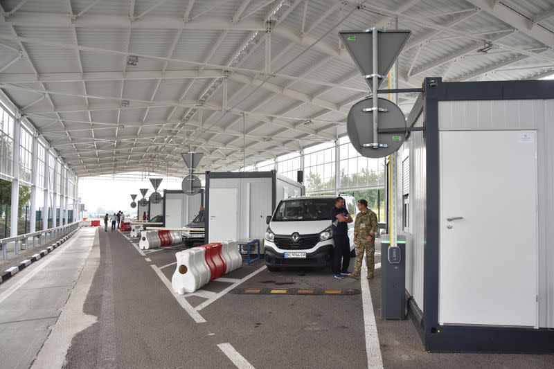 Man speaks to a member of the Ukrainian Border Guard Service at the renovated Ukraine-Poland border crossing point near the village of Krakovets