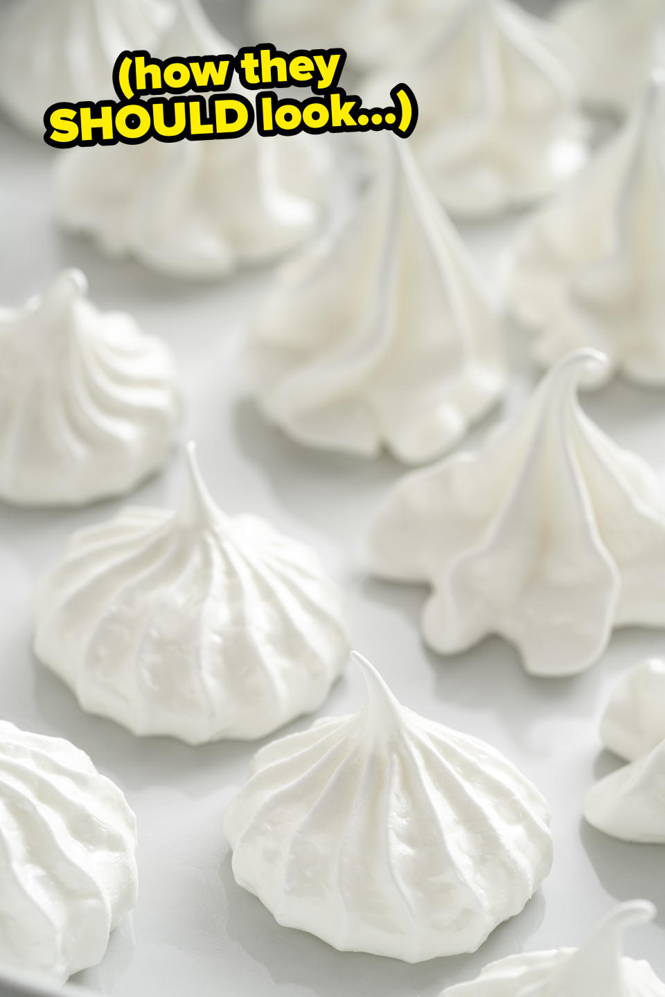White meringues on a sheet tray with text: "how they SHOULD look"