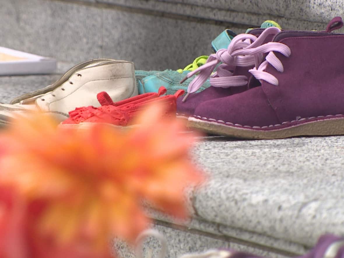 Some of the 215 pairs of shoes placed by Haida artist Tamara Bell on the steps of the Vancouver Art Gallery, pictured on Saturday, May 28, 2022. People gathered at the gallery to reflect on the year that has passed since the shoes were first arranged. (Murray Titus/CBC News - image credit)