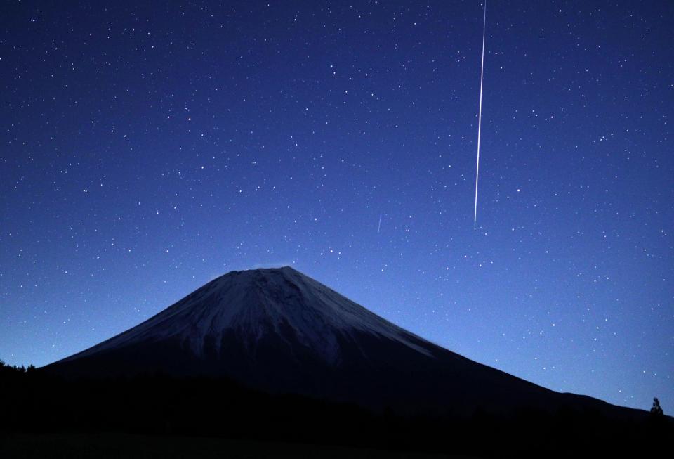 A meteor from the Geminids meteor shower streaks across the sky above Mount Fuji in Fujinomiya, Shizuoka prefecture, Japan: EPA