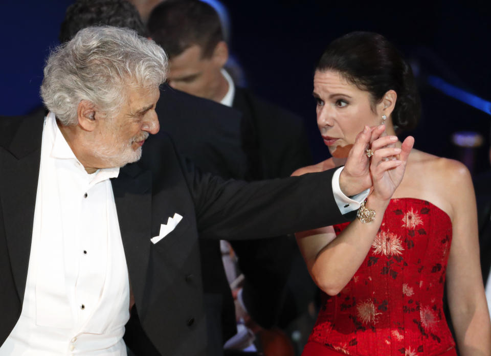 Opera star Placido Domingo holds the hand of Ana Maria Martinez at the end of a concert in Szeged, Hungary, Wednesday, Aug. 28, 2019. Domingo continued his calendar of European engagements unabated despite allegations of sexual harassment, appearing Wednesday at a concert in southern Hungary to inaugurate a sports complex for a local Catholic diocese.(AP Photo/Laszlo Balogh)