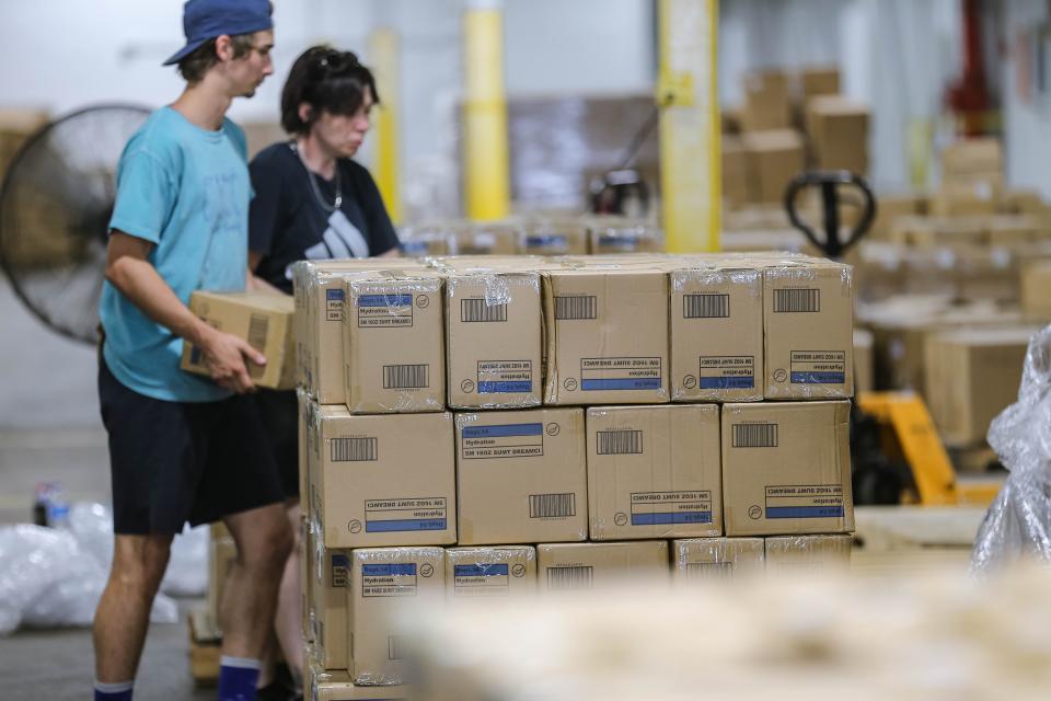 Workers pack boxes July 8, 2022, at the factory of Simple Modern, a local manufacturer of stainless steel, vacuum insulated water bottles, tumblers, and travel mugs, in Oklahoma City.