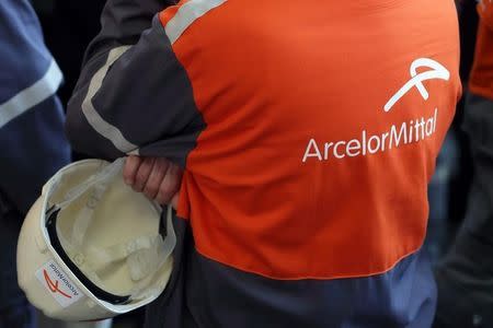 A worker holds his helmet as he listens to French President's speech during a visit at ArcelorMittal steel factory in Florange, Eastern France, September 26, 2013. REUTERS/Philippe Wojazer