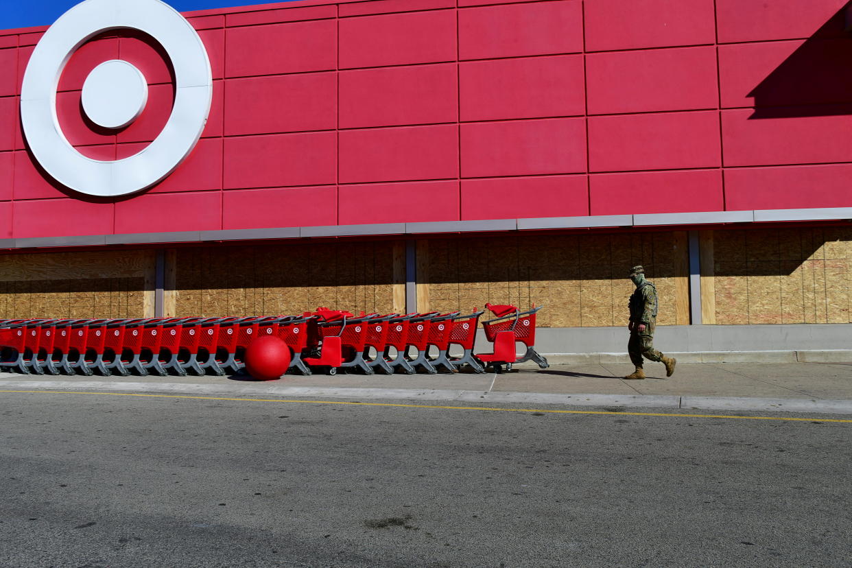 A National Guard member walks outside a Target store, boarded up initially due to unrest following the killing by police of Black man Walter Wallace Jr, in Philadelphia, Pennsylvania, U.S. November 4, 2020. REUTERS/Mark Makela     TPX IMAGES OF THE DAY