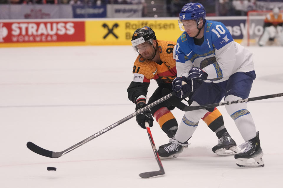 Germany's Moritz Muller, left, challenges for a puck with Kazakhstan's Nikita Mikhailis during the preliminary round match between Germany and Kazakhstan at the Ice Hockey World Championships in Ostrava, Czech Republic, Friday, May 17, 2024. (AP Photo/Darko Vojinovic)