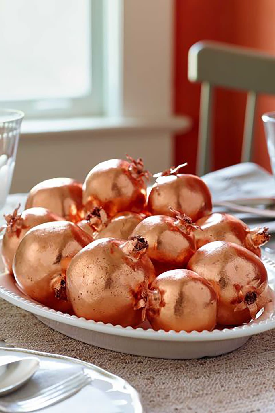 <p>Cover artificial pomegranates with copper leaf for festive decor that will never spoil.</p><p><strong>Step 1: </strong>Insert wooden skewers into artificial pomegranates<em>.</em> Coat each with adhesive size. Stand skewers upright in a piece of Styrofoam; let pomegranates dry until tacky (about 7 minutes).</p><p><strong><strong>Step 2: </strong> </strong>Following manufacturer's instructions, apply sheets of <a href="https://www.amazon.com/Speedball-Mona-Genuine-Copper-Sheet/dp/B001U3X39G/?tag=syn-yahoo-20&ascsubtag=%5Bartid%7C10050.g.2063%5Bsrc%7Cyahoo-us" rel="nofollow noopener" target="_blank" data-ylk="slk:copper leaf;elm:context_link;itc:0;sec:content-canvas" class="link ">copper leaf</a> until pomegranate is covered (approximately 2 sheets). Repeat with each pomegranate. Display on a tray, in a bowl, or on a cake stand.</p><p><strong><a class="link " href="https://www.amazon.com/Gresorth-Pomegranate-Decoration-Artificial-Simulation/dp/B07XTFVMGJ/ref=sr_1_2_sspa?tag=syn-yahoo-20&ascsubtag=%5Bartid%7C10050.g.2063%5Bsrc%7Cyahoo-us" rel="nofollow noopener" target="_blank" data-ylk="slk:SHOP FAUX POMEGRANATES;elm:context_link;itc:0;sec:content-canvas">SHOP FAUX POMEGRANATES</a></strong> </p>