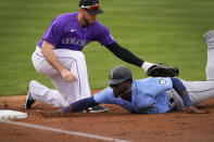 Seattle Mariners' Taylor Trammell dives back safely on a pick-off attempt as Colorado Rockies' C.J. Cron apples the tag during the second inning of a spring training baseball game, Saturday, March 13, 2021, in Scottsdale, Ariz. (AP Photo/Matt York)