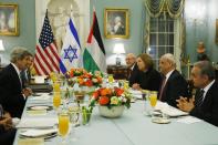 FILE - In this July 29, 2013 file photo, Secretary of State John Kerry, left, sits across from Israel's Justice Minister and chief negotiator Tzipi Livni, third right, Palestinian chief negotiator Saeb Erekat, second right, Yitzhak Molcho, an adviser to Israeli Prime Minister Benjamin Netanyahu, fourth right, and Mohammed Shtayyeh, aide to Palestinian President Mahmoud Abbas, right, at an Iftar dinner, which celebrates Ramadan, at the State Department in Washington, marking the resumption of Israeli-Palestinian peace talks. Nine months of U.S.-driven diplomacy have left Israelis and Palestinians less hopeful than ever about a comprehensive peace agreement to end their century of conflict. Although a formula may yet be found to somehow prolong the talks past an end-of-April deadline, they are on the brink of collapse and the search is already on for new ideas. (AP Photo/Charles Dharapak, File)