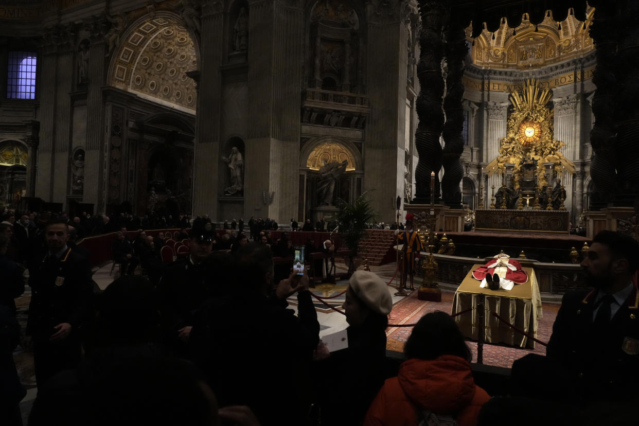 CORRECTS DATE TO JAN. 4 - Mourners view the body of Pope Emeritus Benedict XVI as it lies in state inside St. Peter's Basilica at The Vatican, Wednesday, Jan. 4, 2023. Pope Benedict, the German theologian who will be remembered as the first pope in 600 years to resign, has died, the Vatican announced Saturday, Dec. 31, 2022. He was 95.(AP Photo/Gregorio Borgia)