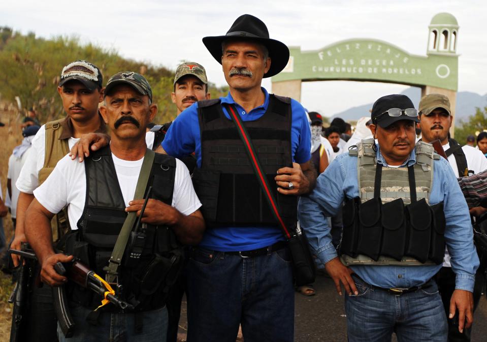 Jose Manuel Mireles, head of Michoacan state's community police, stands with vigilantes in Churumuco