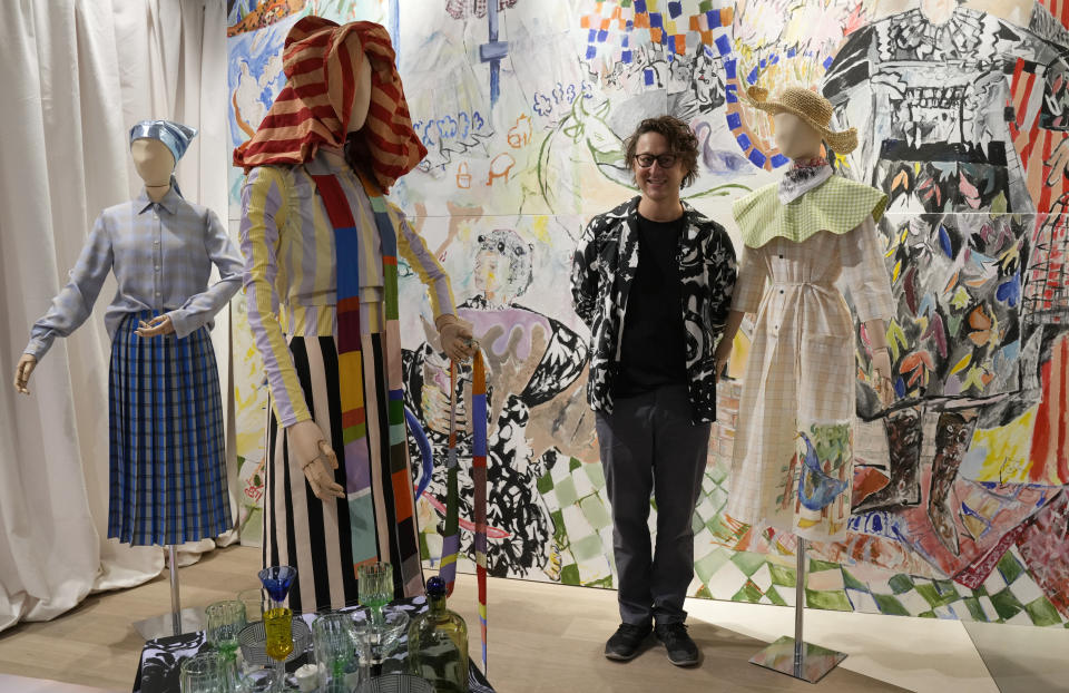 Designer Arthur Arbesser poses next to his creations as part of the women's Spring Summer 2022 collection, unveiled during the Fashion Week in Milan, Italy, Saturday, Sept. 25, 2021. (AP Photo/Antonio Calanni)