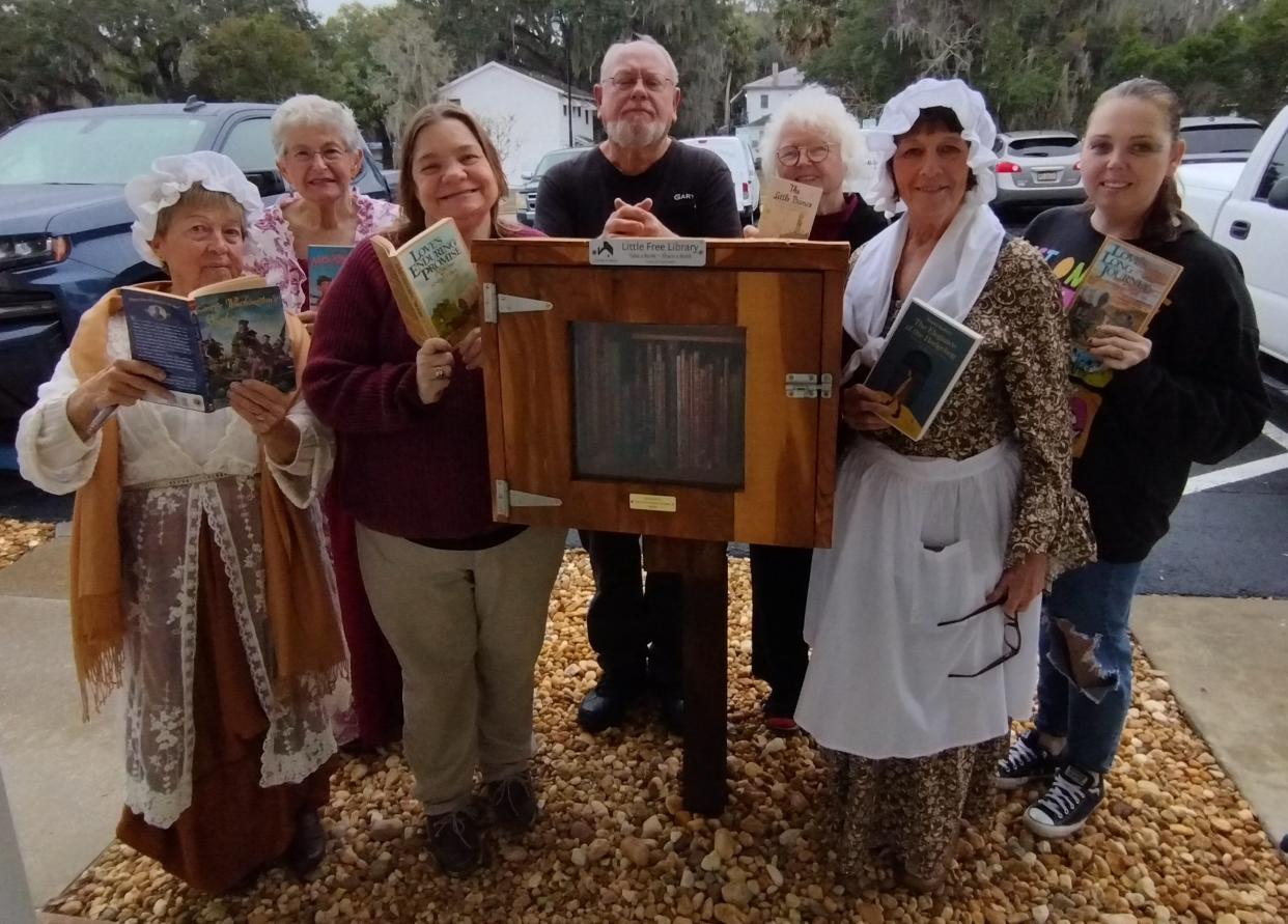 Judy Lewi, Charyl Winner, Stephanie Haw, Gary Hicks, Elaine Brown, Eileen Alvarez and Candy Davis celebrate the new Little Free Library in Leesburg.