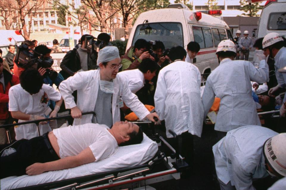 In this March 20, 1995, photo, subway passengers affected by sarin gas planted in central Tokyo subways are carried into St. Luke's International Hospital in Tokyo. (Chikumo Chiaki/AP)