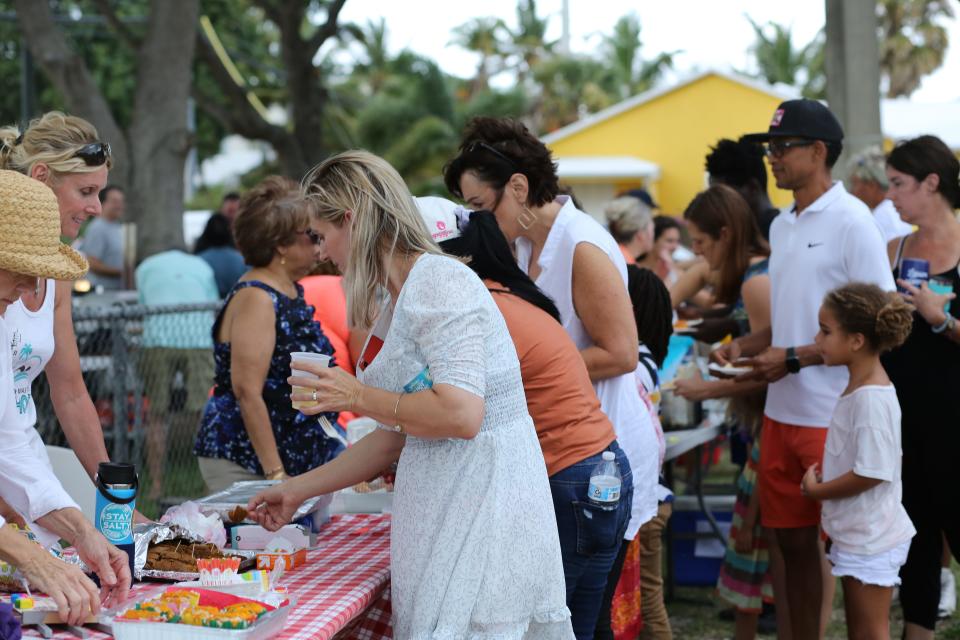 Visitors to the 2021 Osceola Park Mango Swap sample the dishes made by their neighbors.