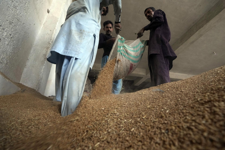 Pakistani workers sort the wheat in a warehouse in Karachi, Pakistan, on Wednesday, July 26, 2023. (AP Photo/Fareed Khan)