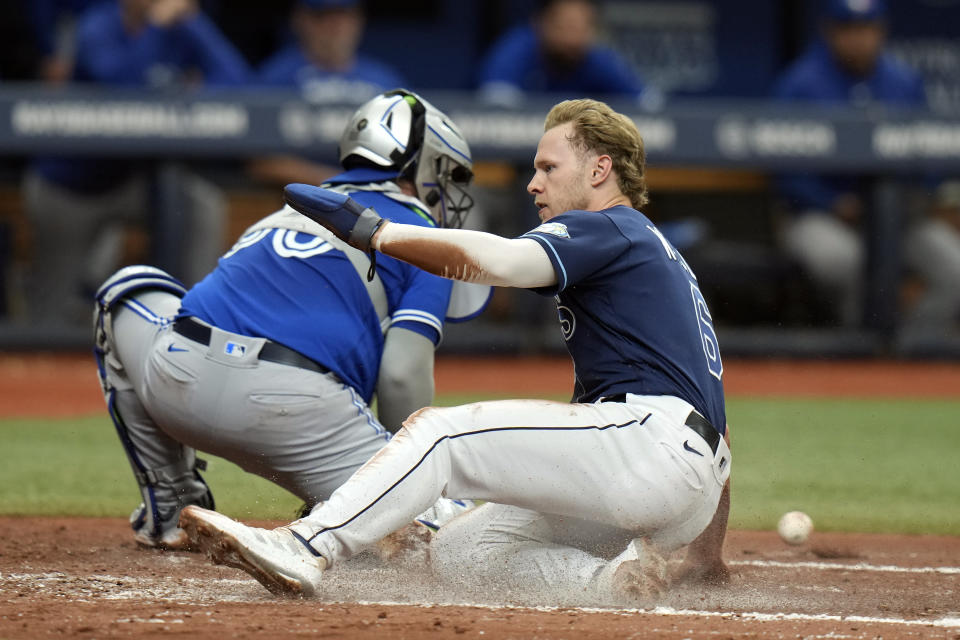 Tampa Bay Rays' Taylor Walls scores ahead of the throw to Toronto Blue Jays catcher Alejandro Kirk (30) during the third inning of a baseball game Thursday, May 25, 2023, in St. Petersburg, Fla. (AP Photo/Chris O'Meara)