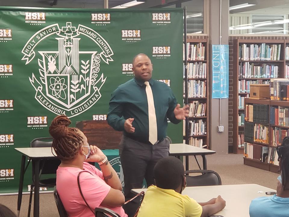 Kendrick Moore talks to players and parents of the Menard boys basketball team after being introduced as head coach.