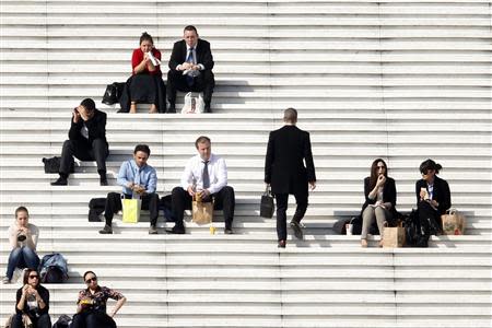 Businessmen enjoy the good weather at lunch time on the steps of the Arche de la Defense, in the financial and business district west of Paris, as warm and sunny weather continues in France, March 13, 2014. REUTERS/Charles Platiau