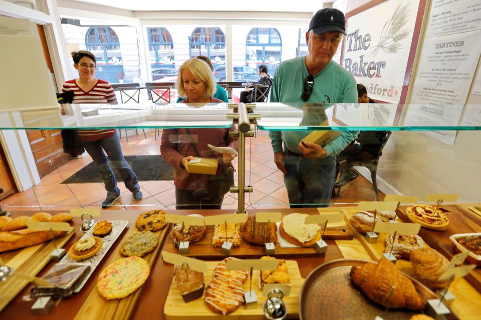 Sara Shwartz, Susan Okolita and James Okolita grab their food boxes at The Baker during a food tour through the various eating establishments in New Bedford.