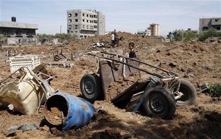 A Palestinian boy looks at the scene of an Israeli air strike in the central Gaza Strip April 21, 2014. REUTERS/Ibraheem Abu Mustafa