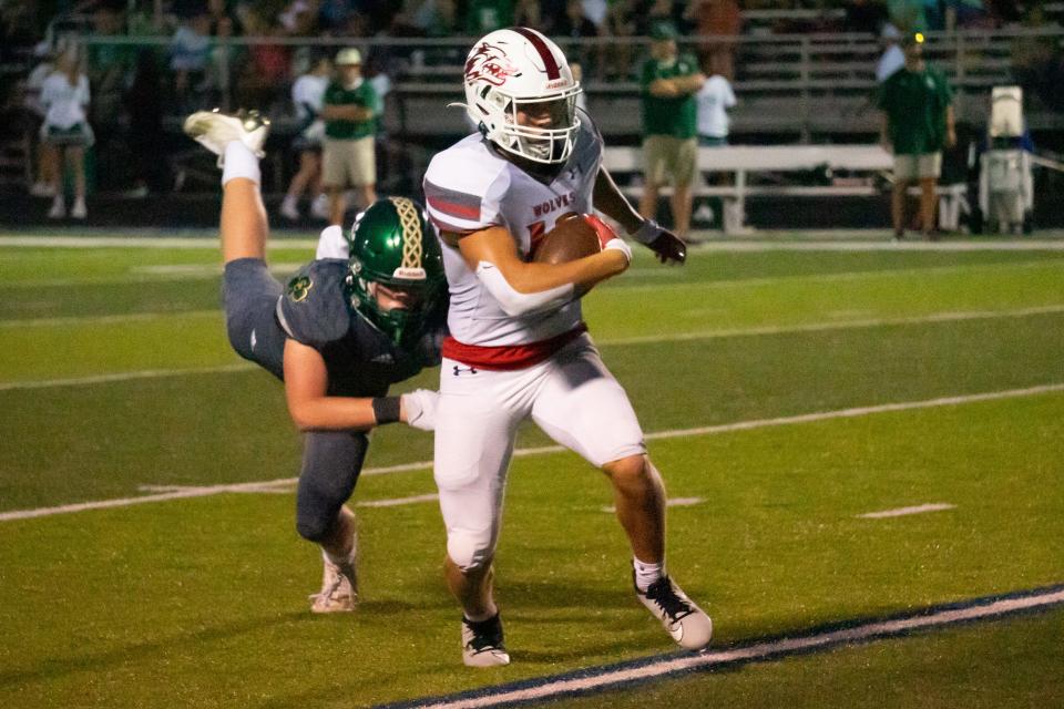 Reeds Spring Receiver James Dowdy (#13) shakes off Springfield Catholic defender Clayton Stuhlsatz (#2) for a short gain.