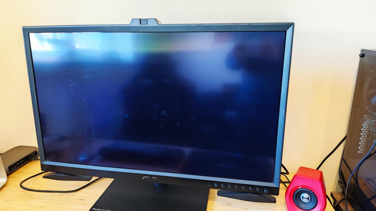  A black ASUS ProArt OLED PA32DC monitor sitting on a desk. 