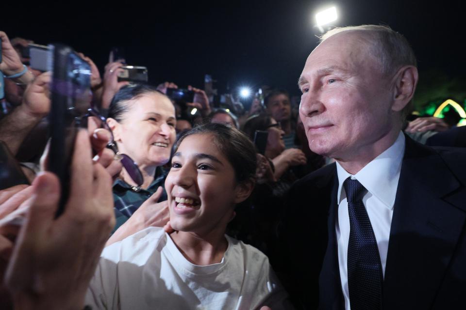 FILE - Russian President Vladimir Putin, right, poses for a selfie with local citizens during his working visit to Dagestan Republic in Derbent, Russia, Wednesday, June 28, 2023. A week after the mutiny raised the most daunting challenge to President Vladimir Putin’s rule in over two decades, key details about the uprising remain shrouded in mystery. (Gavriil Grigorov, Sputnik, Kremlin Pool Photo via AP, File)