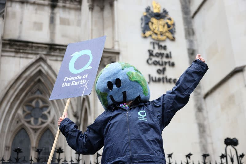 A protestor holds a "Friends of the Earth" placard outside the High Court in London