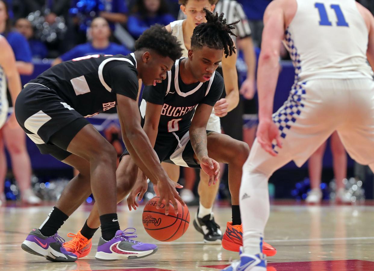 Buchtel Qi'Marreon Marks, left, and Diaire Pride Jr., center, scramble for a loose ball during the second half of a Division II state semifinal basketball game against Bishop Ready at UD Arena, Friday, March 17, 2023, in Dayton, Ohio.