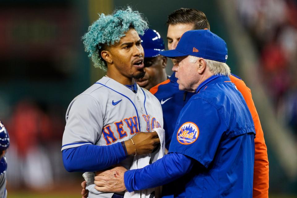 New York Mets shortstop Francisco Lindor, left, is pulled from the game by manager Buck Showalter, right, after he was hit by a pitch during the fifth inning of a baseball game against the Washington Nationals at Nationals Park, Friday, April 8, 2022, in Washington. (AP Photo/Alex Brandon)