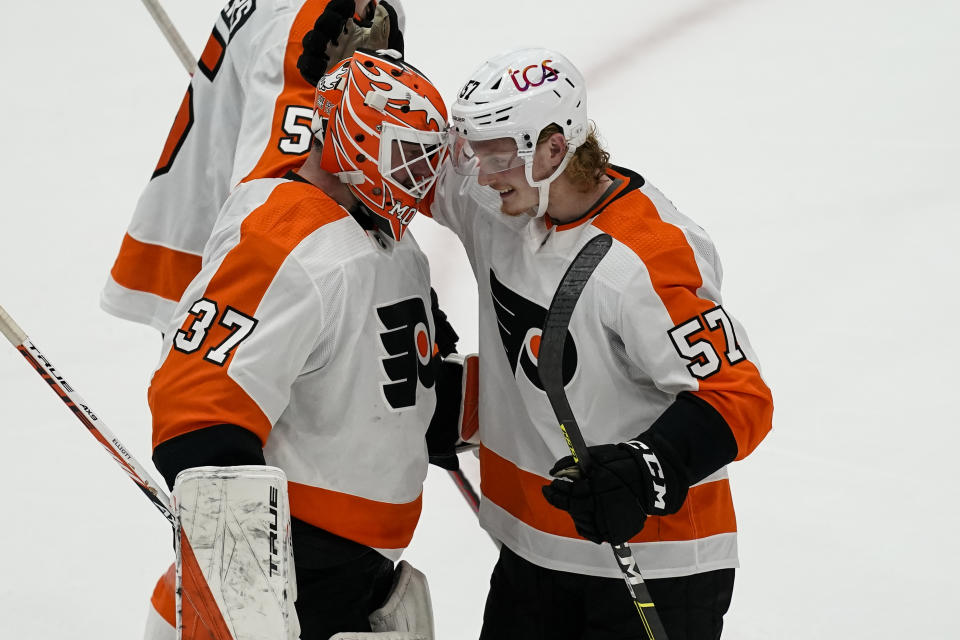 Philadelphia Flyers goaltender Brian Elliott (37) and right wing Wade Allison (57) celebrate after during an NHL hockey game against the Washington Capitals, Friday, May 7, 2021, in Washington. The Flyers won 4-2. (AP Photo/Alex Brandon)