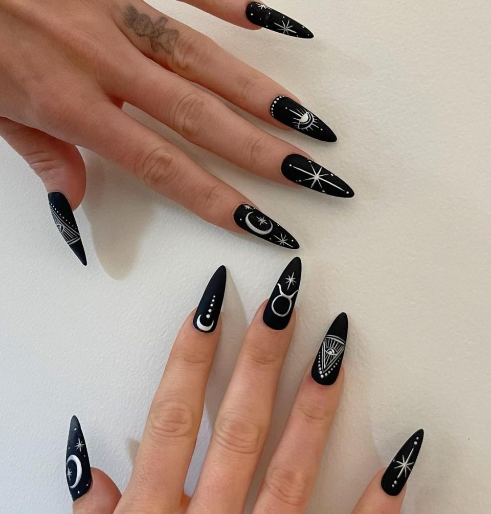 Goth glam queen Megan Fox may have worn these for her birthday in May (peep the Taurus symbol), but this goth glam mani is ideal for Halloween. Get the look with <a href="https://www.amazon.com/Black-Press-Nails-Short-Almond/dp/B0C3GDT517" rel="nofollow noopener" target="_blank" data-ylk="slk:press-on nails;elm:context_link;itc:0;sec:content-canvas" class="link ">press-on nails</a>.