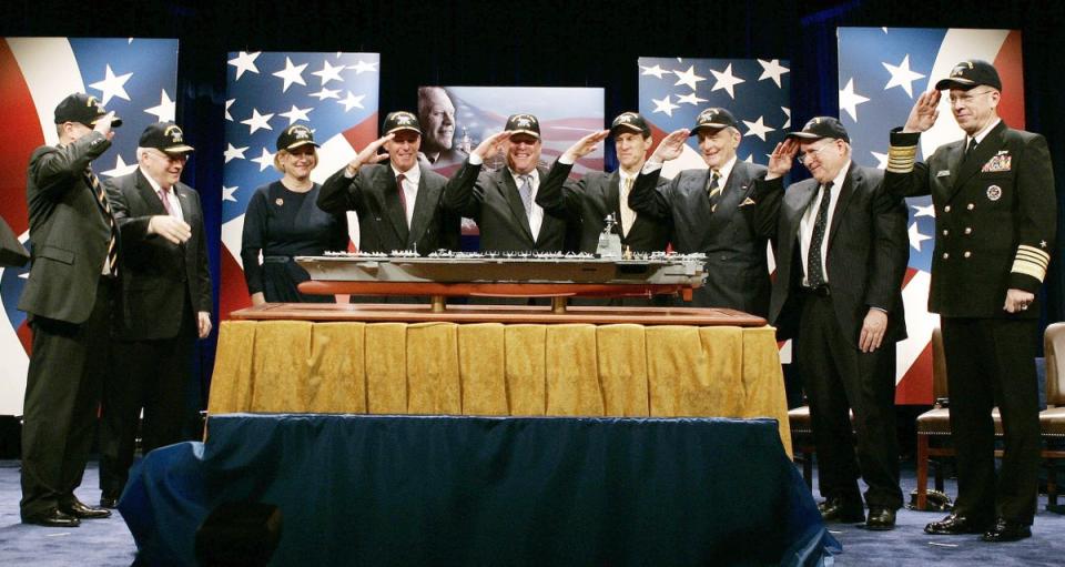 Government officials and family members of former US President Gerald Ford salute a model of a new aircraft carrier named the USS Gerald R. Ford during a naming ceremony at the Pentagon in Washington, 16 January 2007 (AFP via Getty Images)