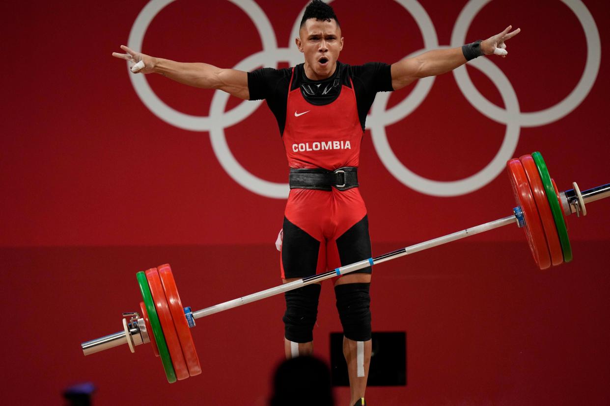 Luis Javier Mosquera Lozano of Colombia celebrates after a lift as he competes in the men's 67kg weightlifting event at the 2020 Summer Olympics, Sunday, July 25, 2021, in Tokyo, Japan.