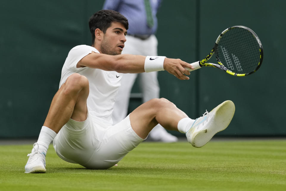 Carlos Alcaraz of Spain falls during his fourth round match against Ugo Humbert of France at the Wimbledon tennis championships in London, Sunday, July 7, 2024. (AP Photo/Alberto Pezzali)