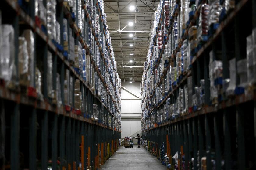 RIVERSIDE, CA -- APRIL 28: Associates fill orders for both Ralphs and Food 4 Less grocery stores at the Ralphs Distribution Center on Tuesday, April 28, 2020, in Riverside, CA. The 80 acre, 1.2 million square feet, full service distribution center employing 1100 workers took on more product after automated warehouses couldn't keep up with the spike in demand after restaurants were shuttered. (Gary Coronado / Los Angeles Times)